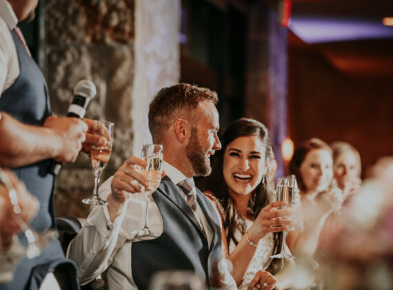 Wedding couple cheers at head table