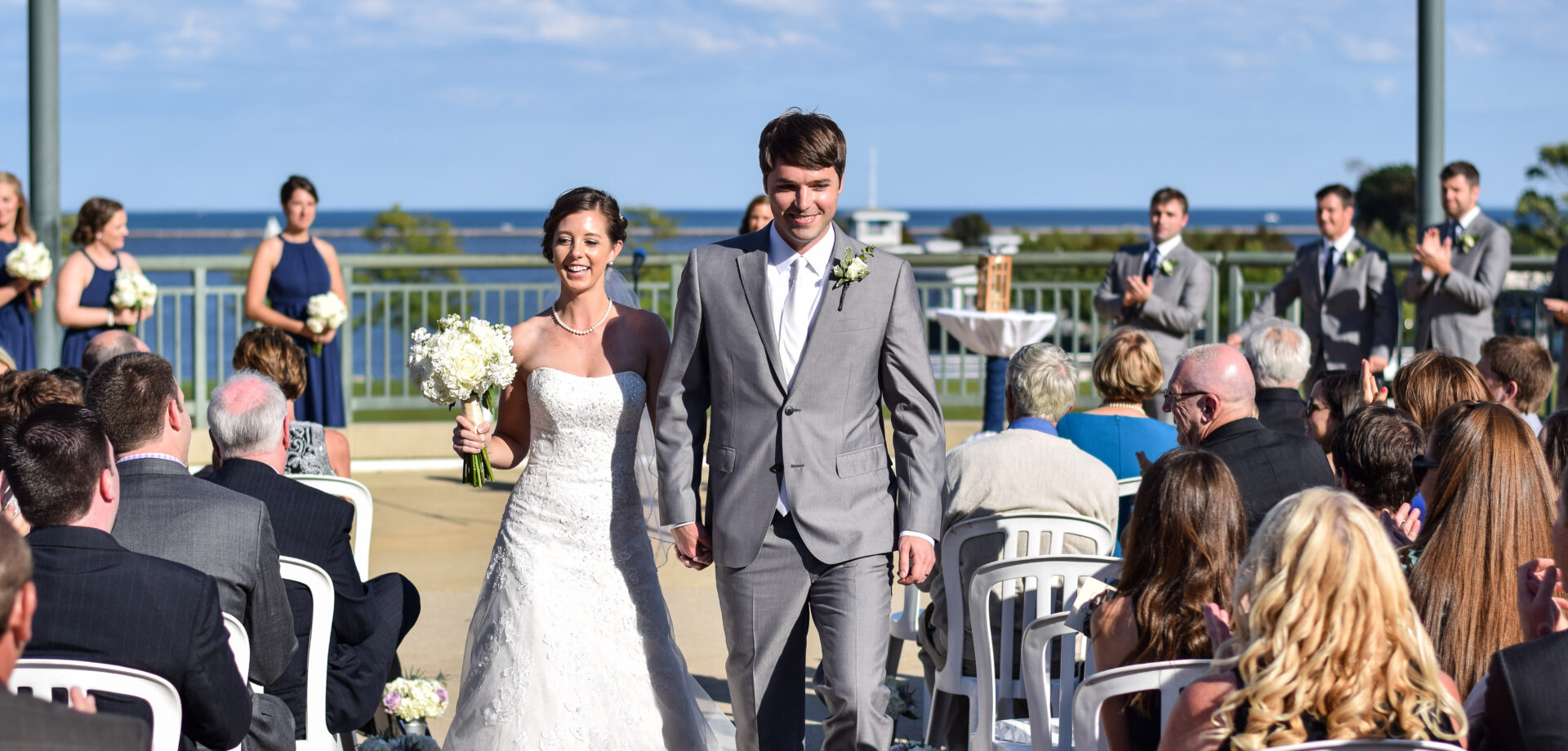 Wedding couple walking outdoor aisle before lake Michigan